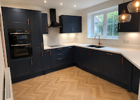 Navy kitchen with herringbone flooring and white worktops