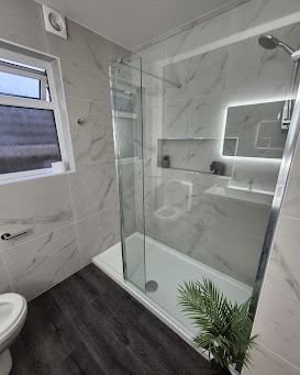 Bathroom with white marble-effect walls and dark wood-effect flooring