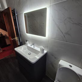 Marble-effect bathroom with backlit mirror and dark vanity
